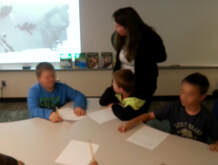 Photo of Roxanne Troup speaking with young students during a writing workshop school visit